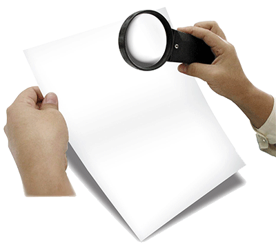 hands holding magnifying glass looking at paper